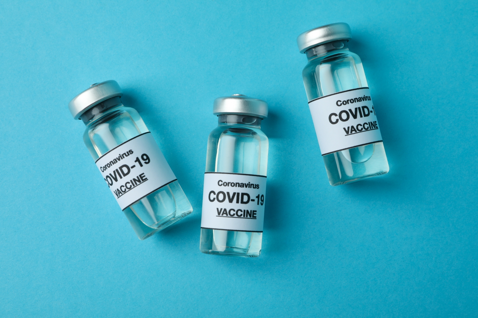 Vials of Covid - 19 vaccine on blue background